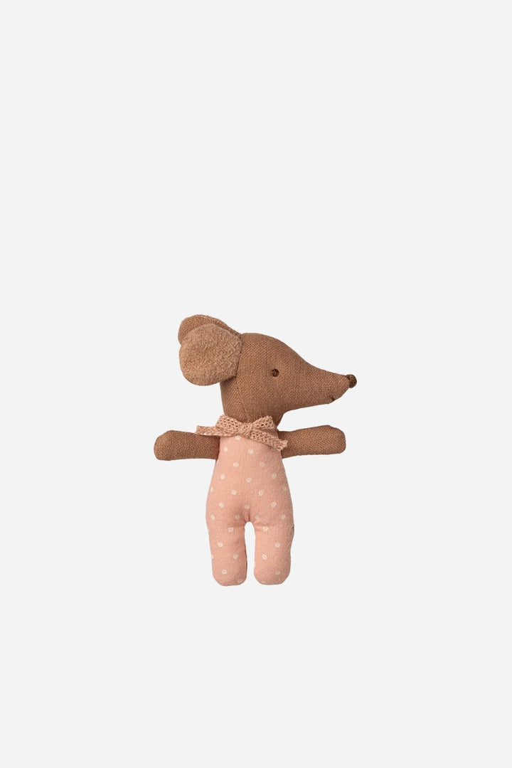 Stuffed toy mouse in a polka dot outfit on a light beige background