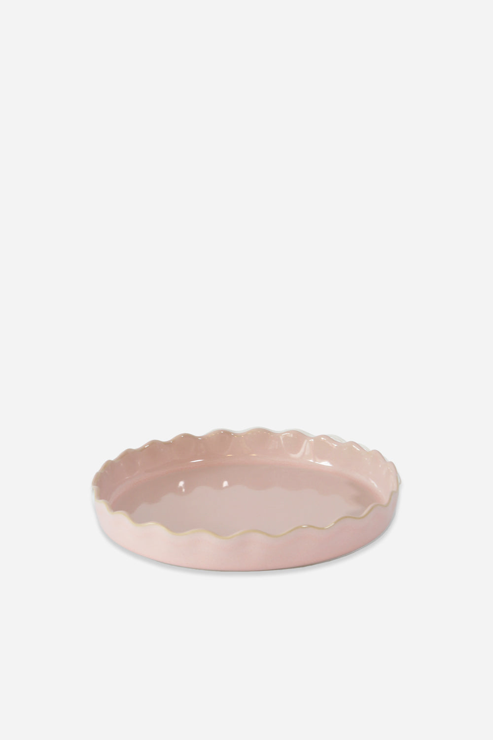 Pink ceramic dish with scalloped edge on a white background