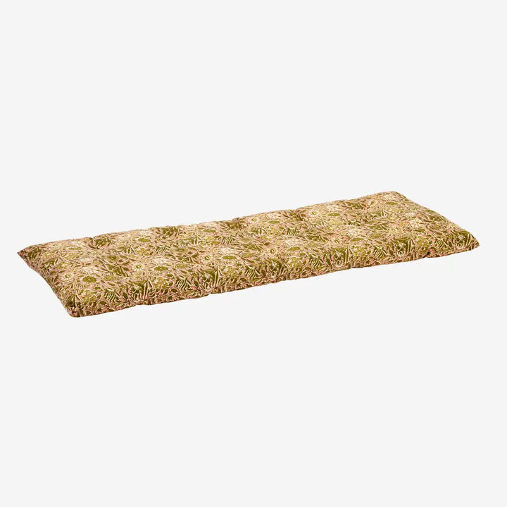 A rectangular outdoor cushion with a tufted grass pattern in shades of green and tan, shown on a plain light gray background.