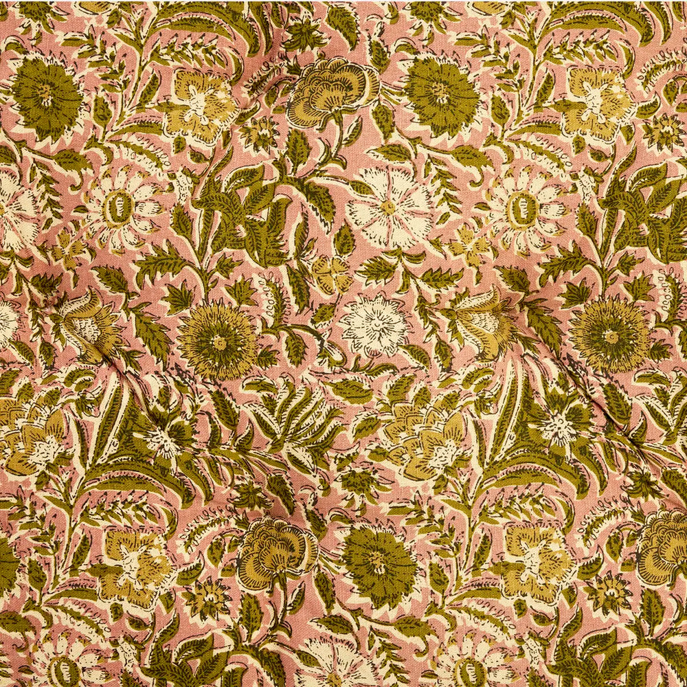 A close-up of a floral fabric pattern featuring olive green, mustard yellow, and cream flowers with green leaves on a dusty pink background.
