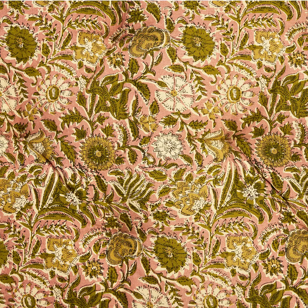 A close-up of a floral fabric pattern featuring olive green, mustard yellow, and cream flowers with green leaves on a dusty pink background.