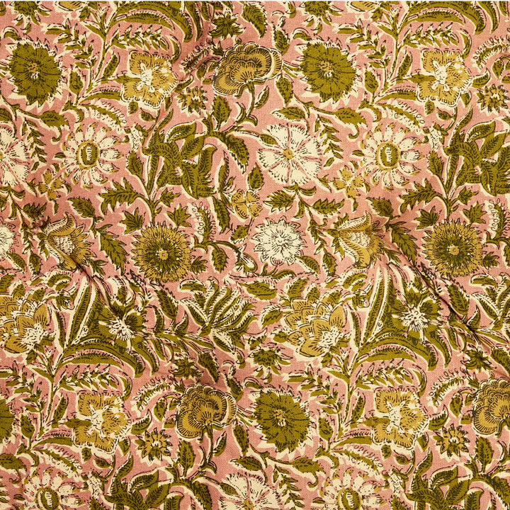 A close-up of a floral fabric pattern featuring olive green, mustard yellow, and cream flowers with green leaves on a dusty pink background.