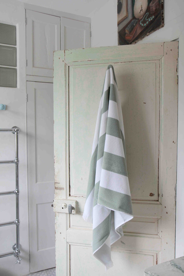 porto white and jade striped beach towel on vintage door hook