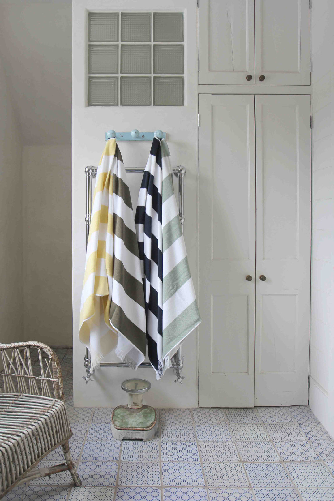 porto striped beach towels hanging in vintage style bathroom
