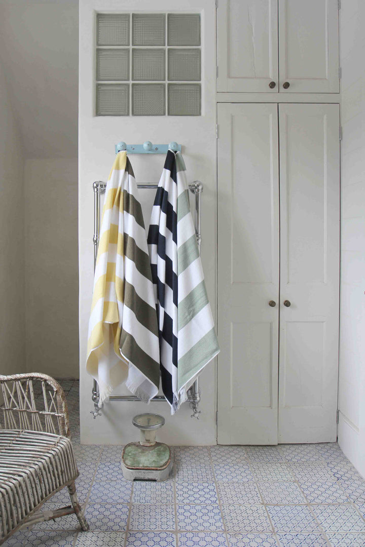 porto striped beach towels hanging in vintage style bathroom