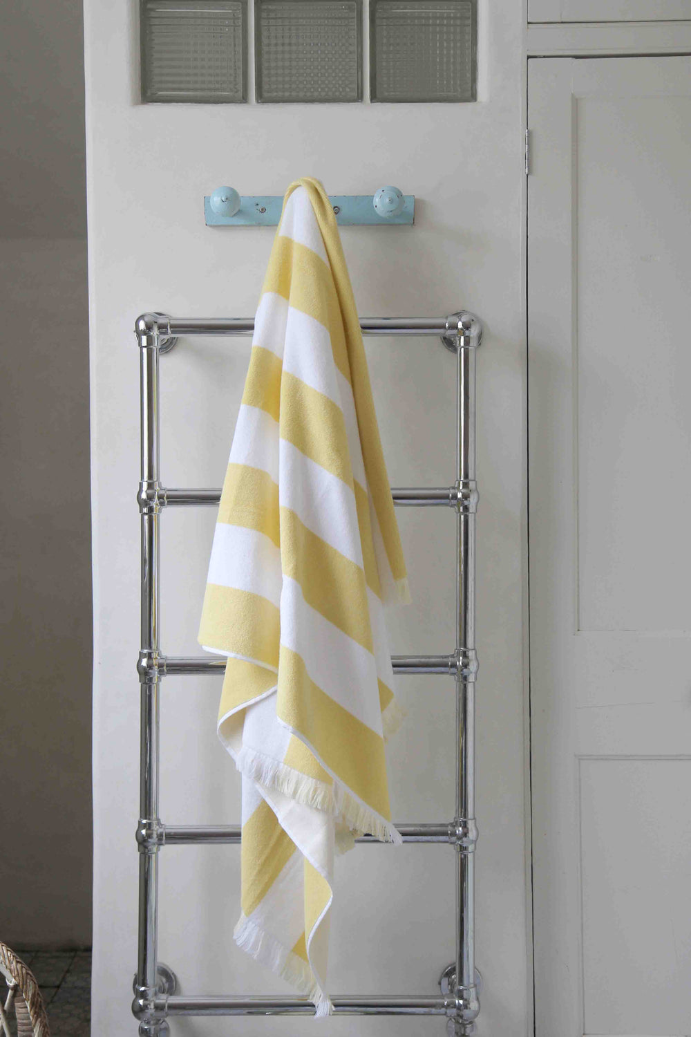 bathroom lifestyle of yellow and white stripe beach towel