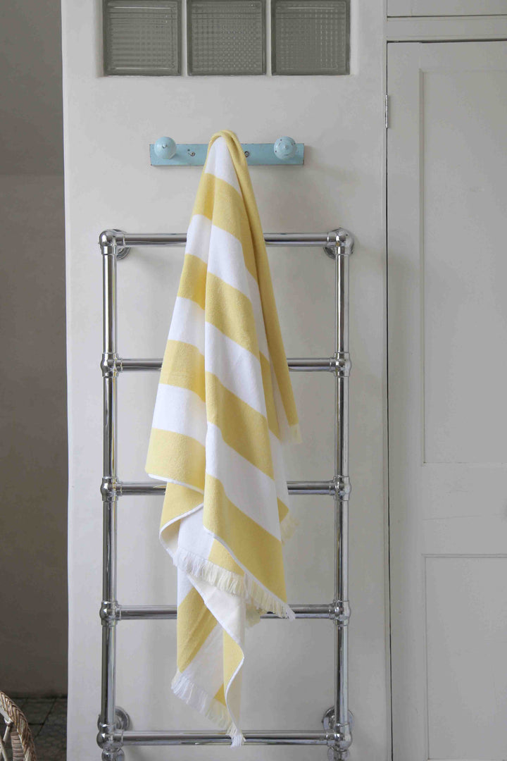 bathroom lifestyle of yellow and white stripe beach towel