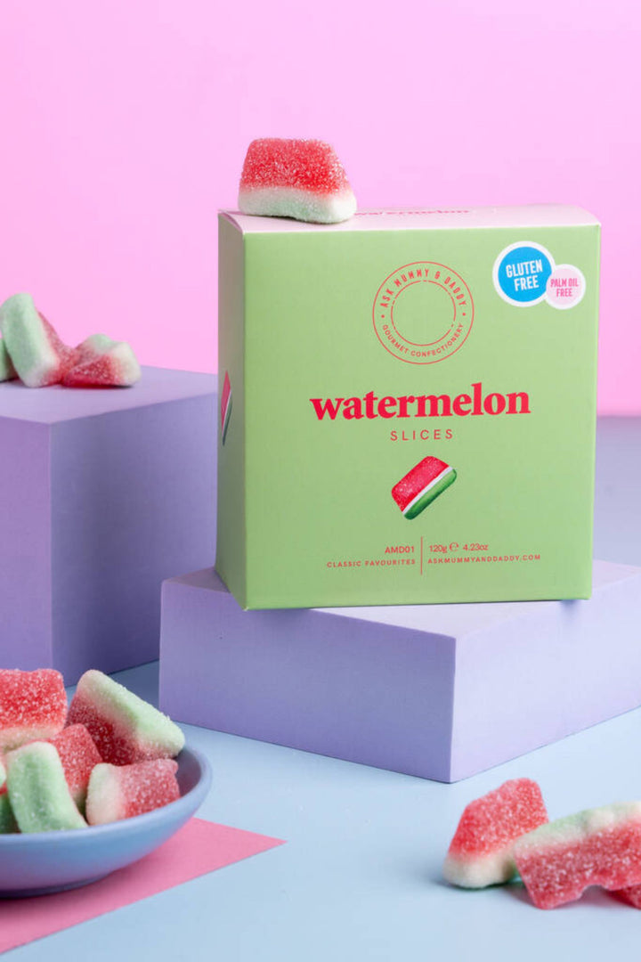 Box of watermelon-flavored gummy slices on a colorful geometric background