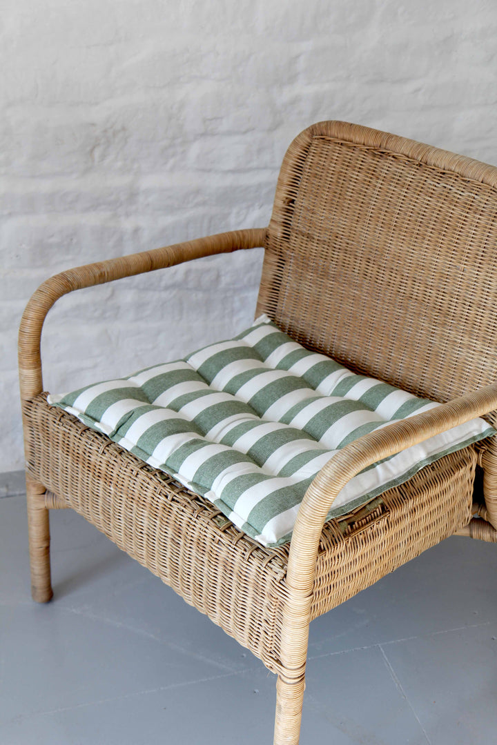 green and white striped cotton seat cushion on rattan chair