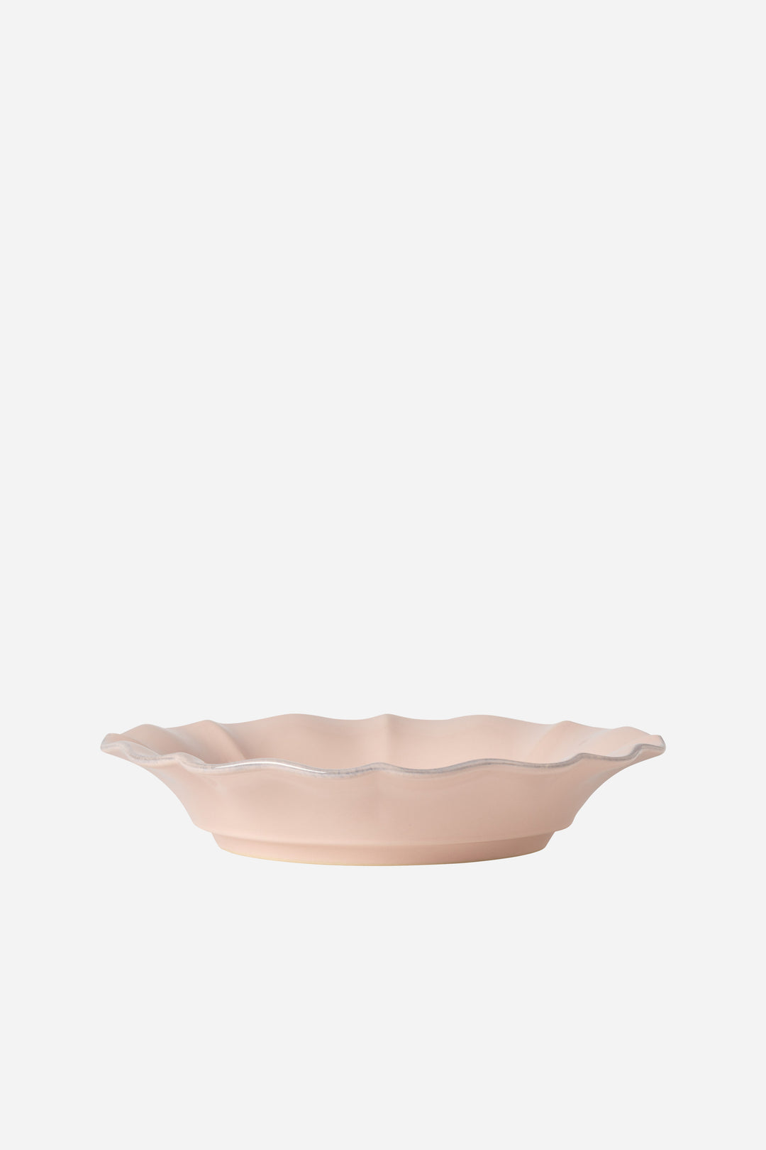 Pink ceramic soup bowl with scalloped edge on a white background