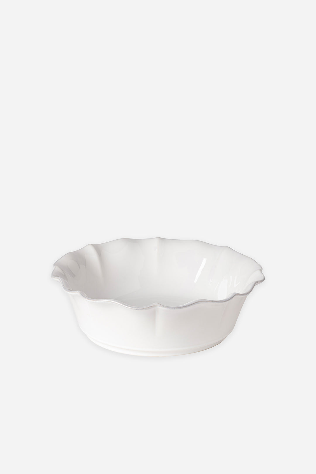 White ceramic serving bowl with scalloped edge on a white background