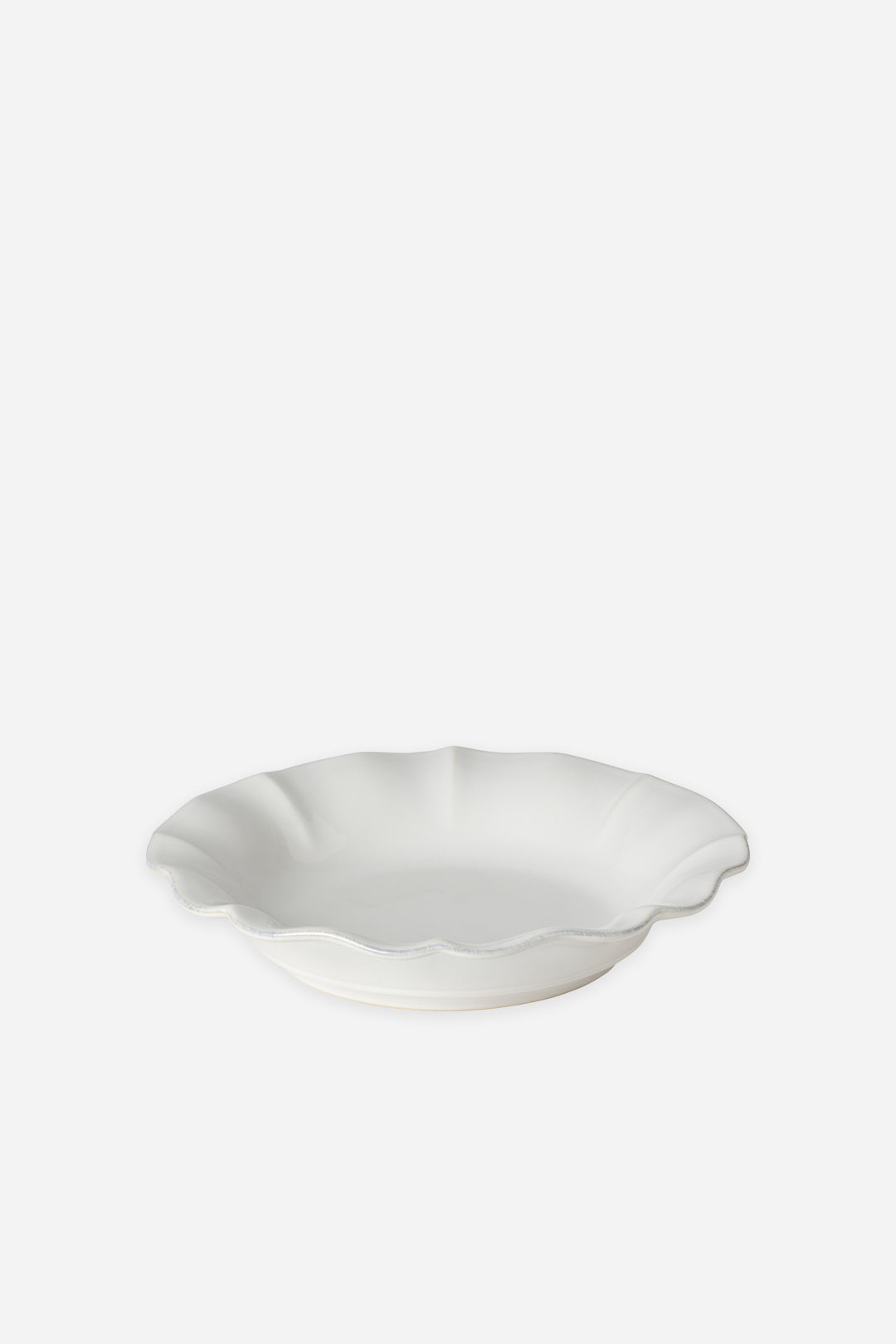 White ceramic bowl with scalloped edge on a white background