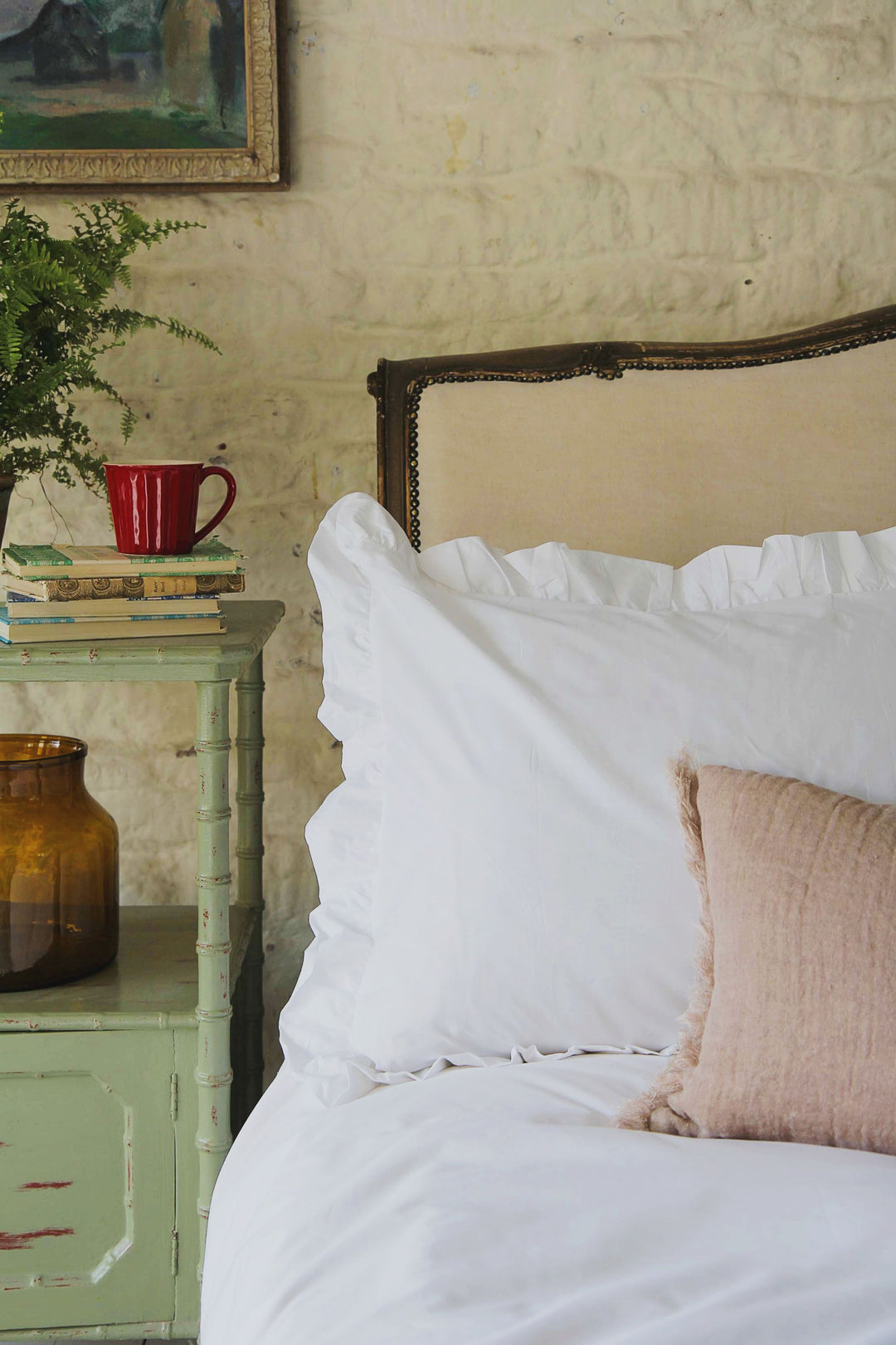 white ruffle edged pillowcase on vintage french bed