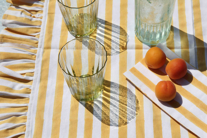 ruffle stripe table runner in yellow on garden table with apricots