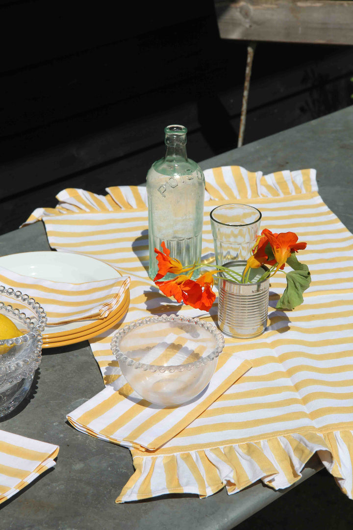 ruffle stripe table runner in yellow on zinc garden table