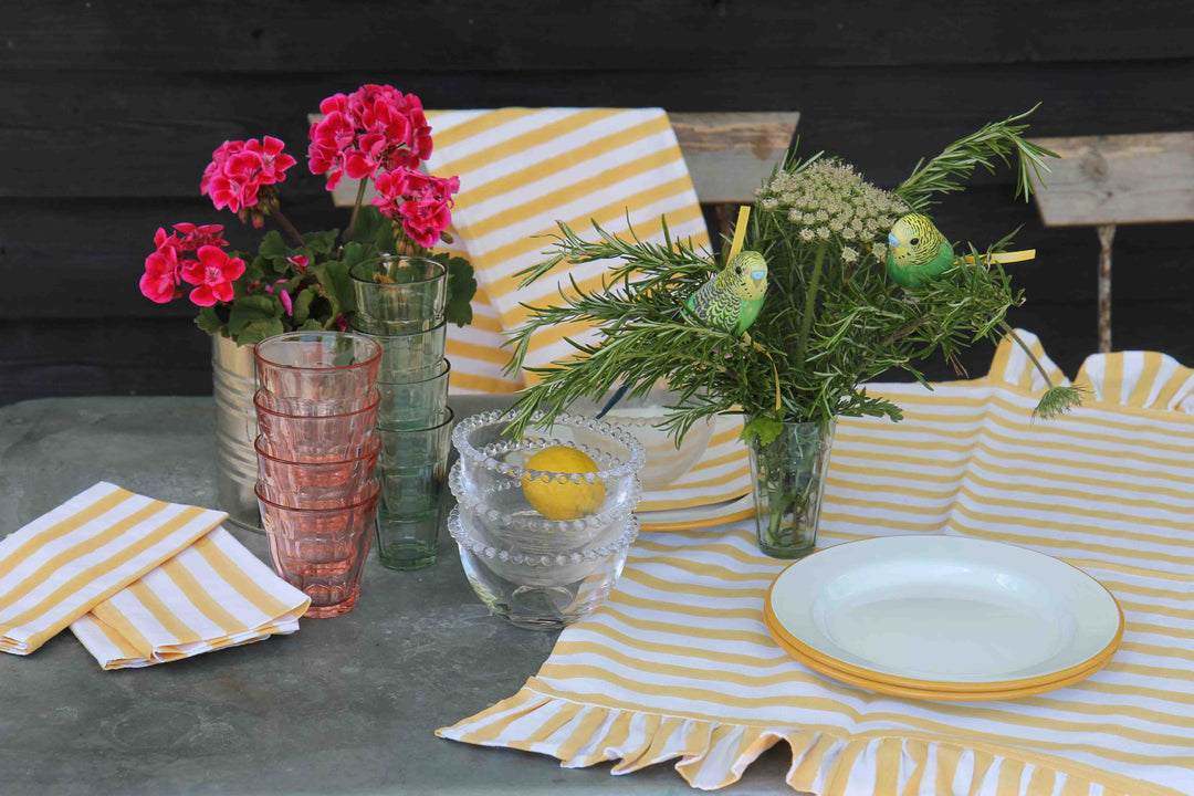 ruffle stripe table runner in yellow on garden table with rosemary