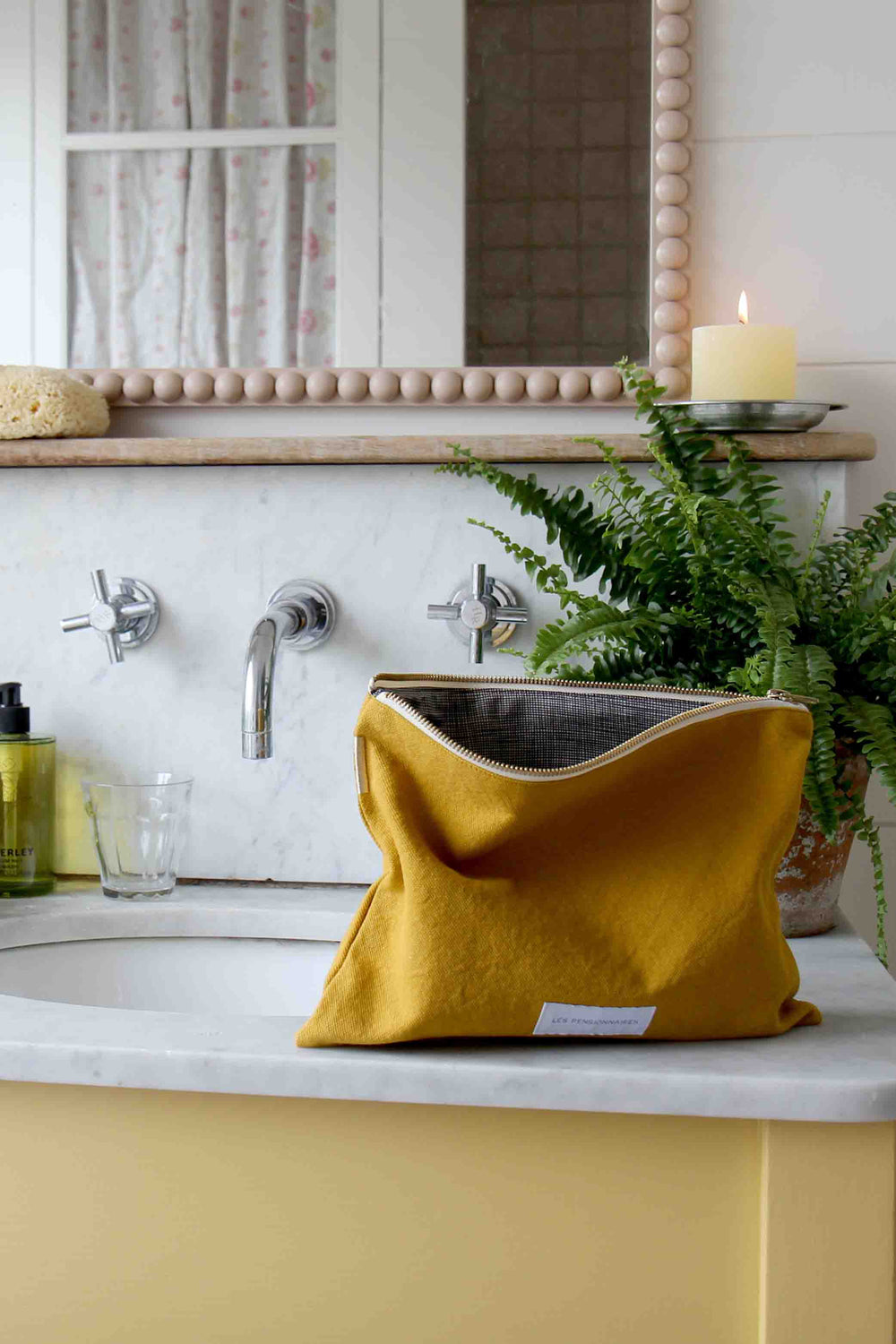 les pensionnaires saffron toiletry bag in yellow bathroom