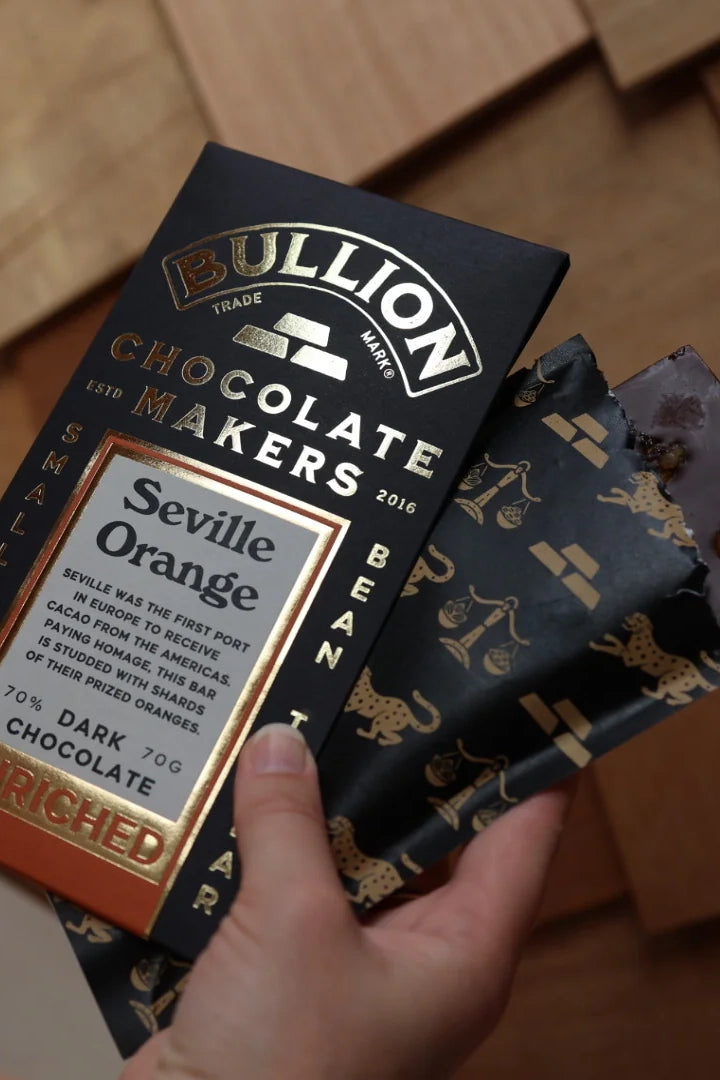 Bullion Chocolate Makers Seville Orange dark chocolate bar held by a hand