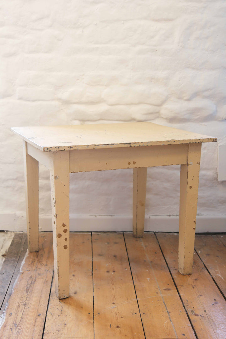 Wooden table against a textured white wall on a wooden floor