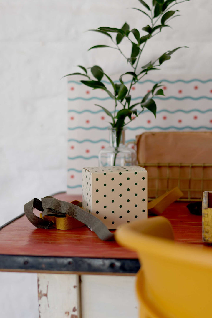 Decorative items on a table with a polka dot wall in the background