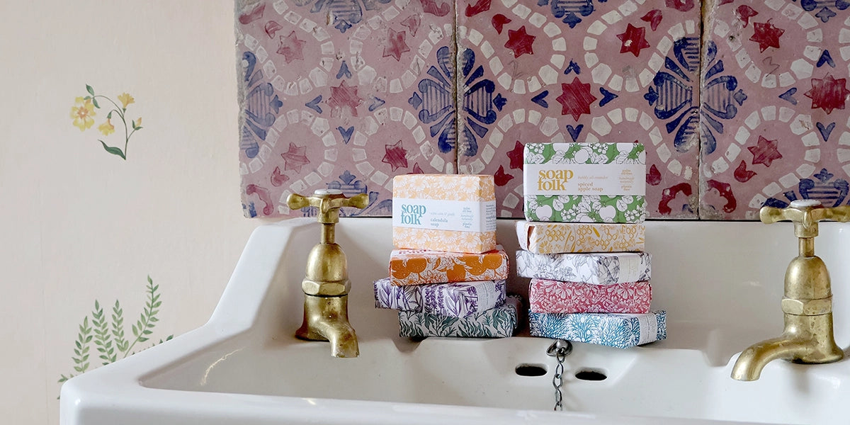 Stacks of soap bars on a sink with decorative tiles in the background