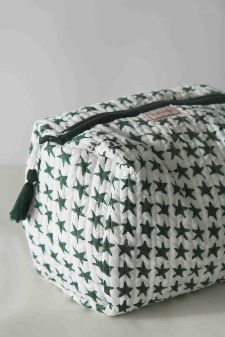 White pouch with green star pattern and black zipper on a light gray background