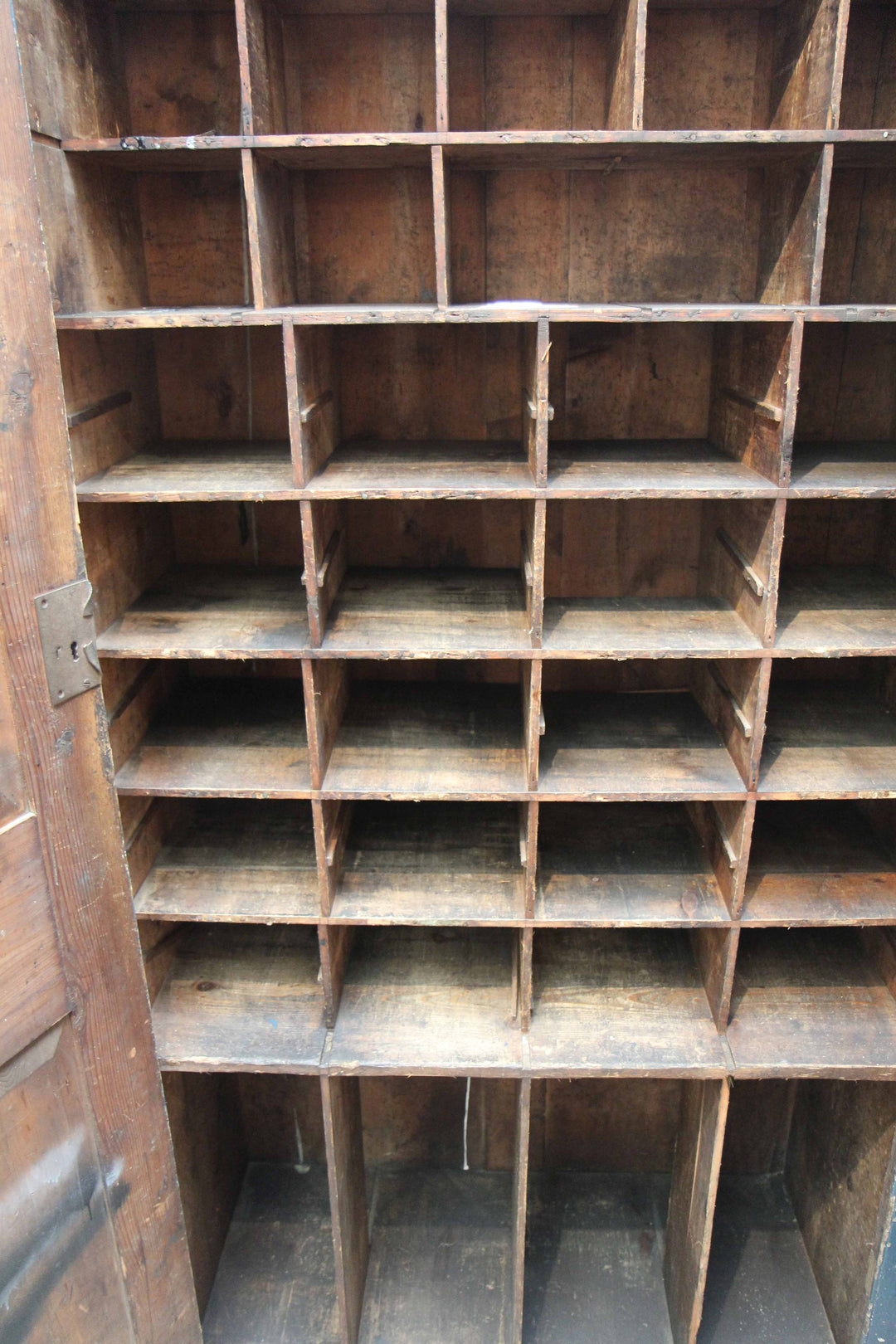 inside of vintage tall cupboard with wooden pigeon hole compartments