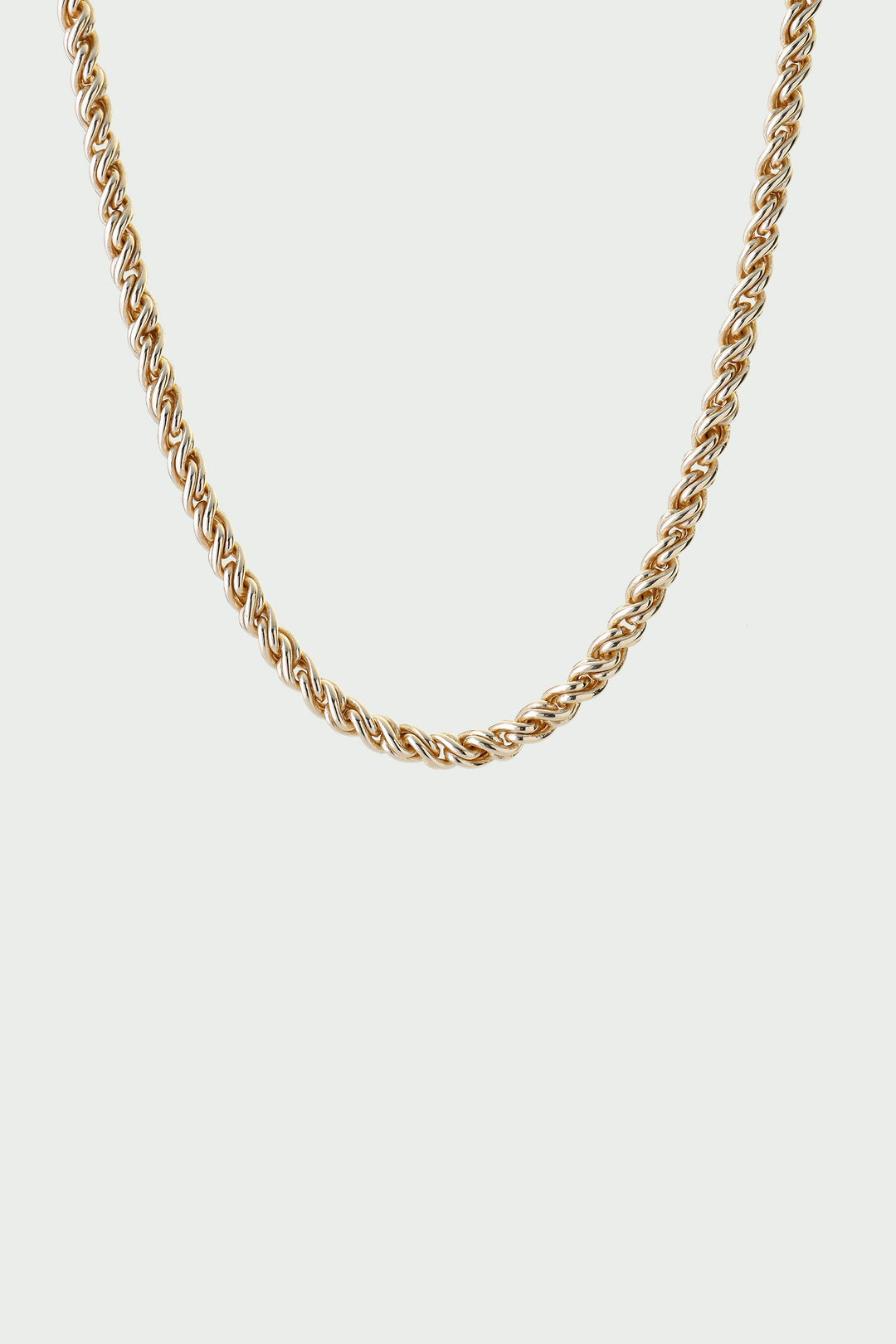 Gold chain necklace on a light gray background
