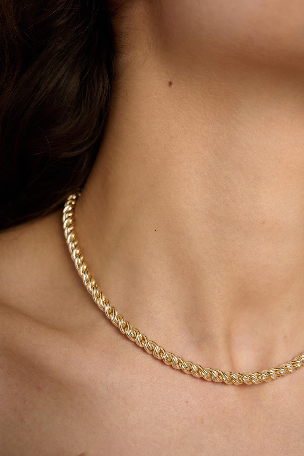 Gold chain necklace on a person's neck