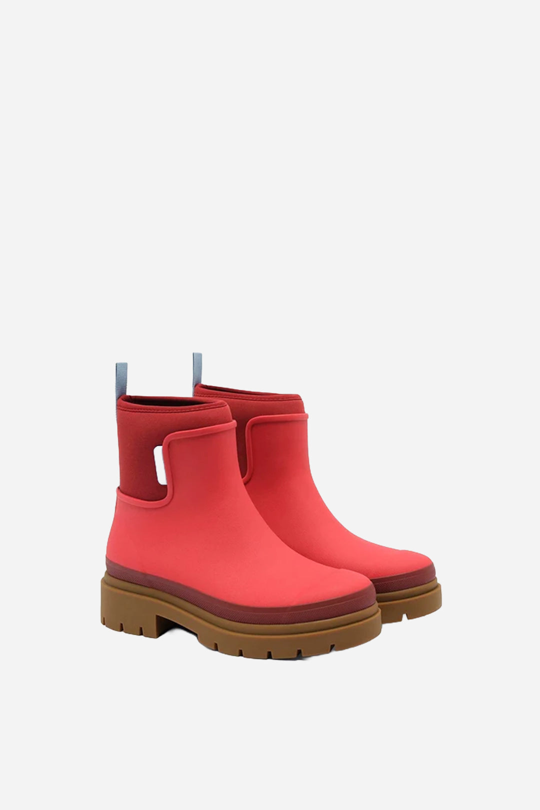 A pair of red rubber rain boots with brown lug soles and light blue pull tabs, shown on a light gray background.