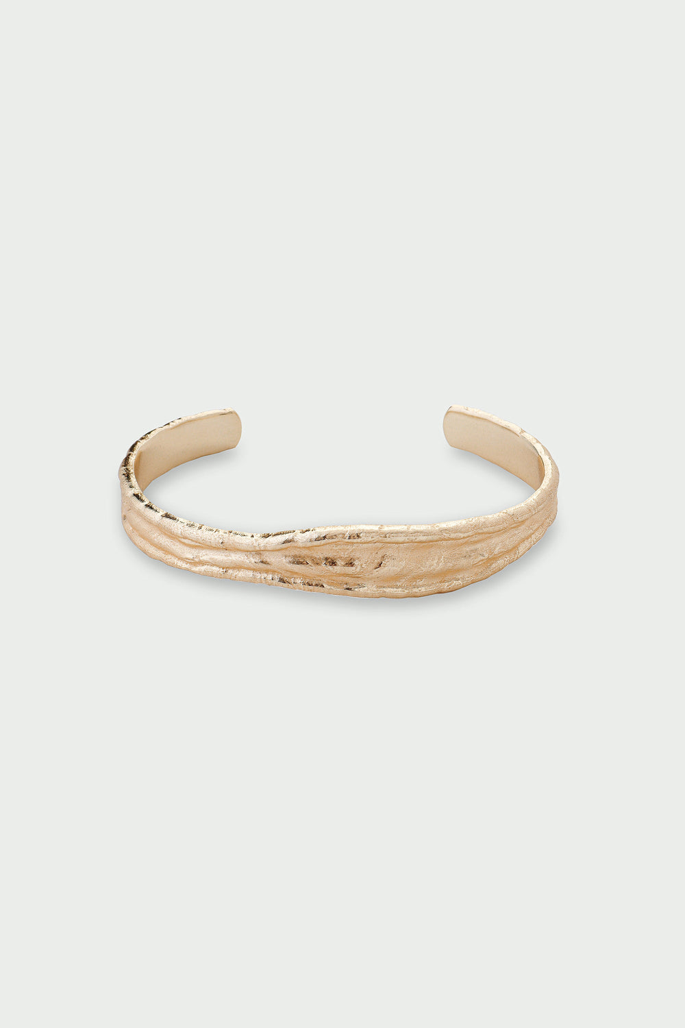 Gold bracelet on a light gray background