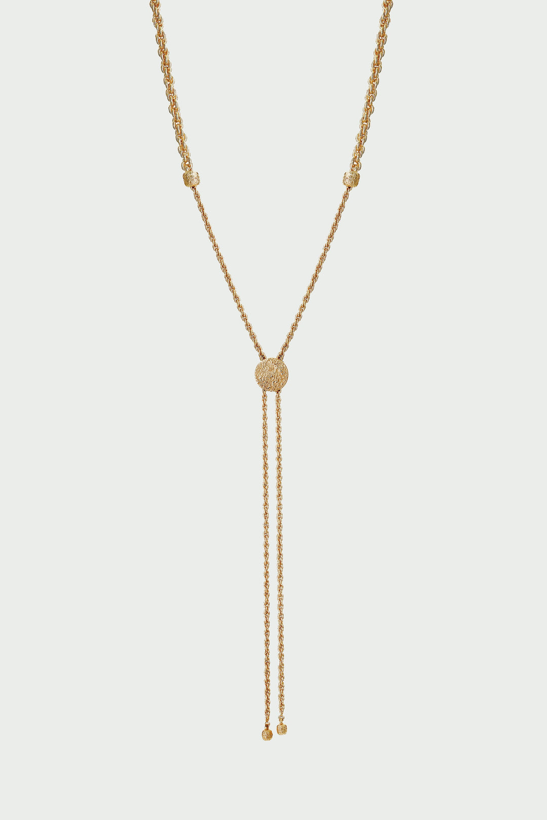 Gold necklace with a y-style clasp on a light gray background