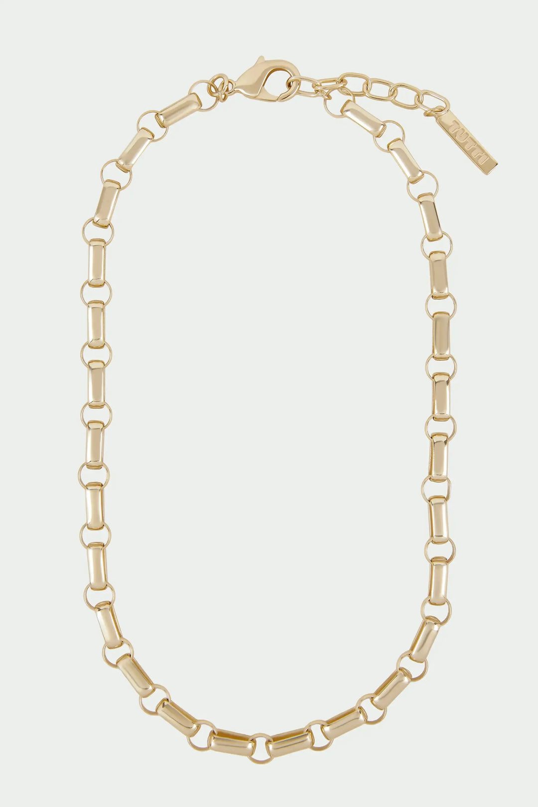 Gold chain necklace on a light beige background