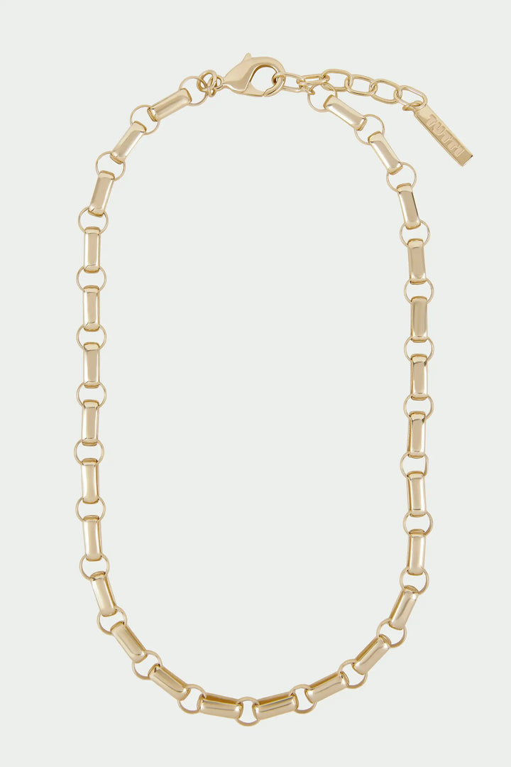 Gold chain necklace on a light beige background
