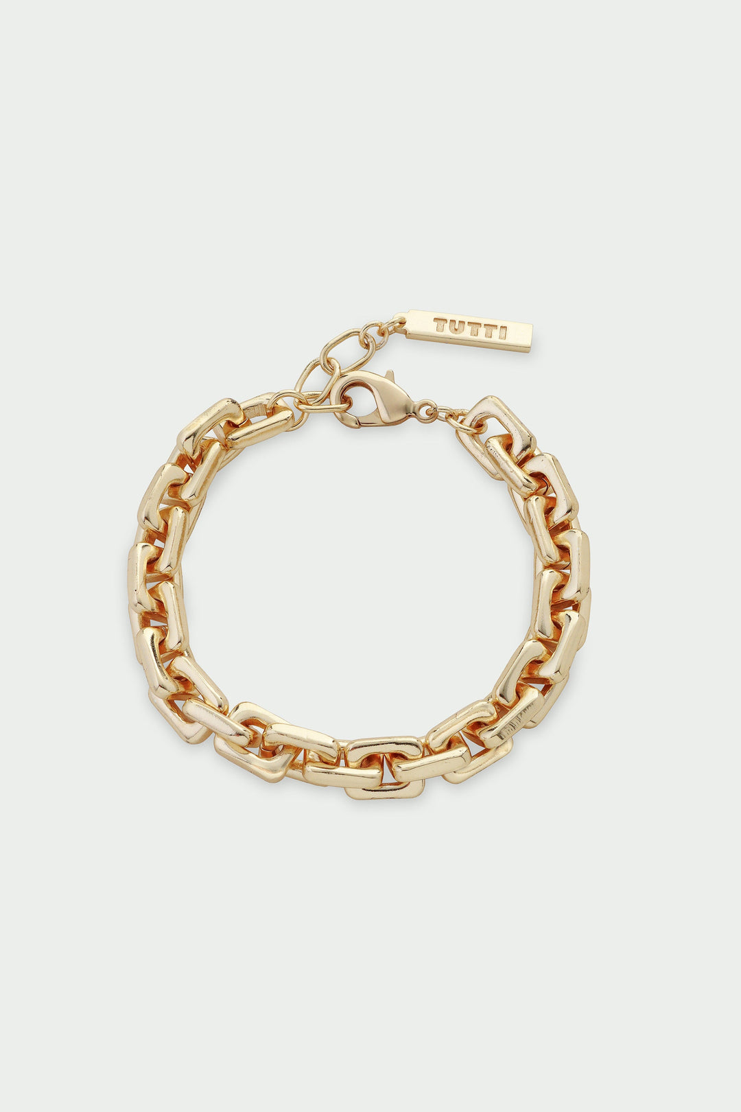 Gold chain bracelet on a light beige background