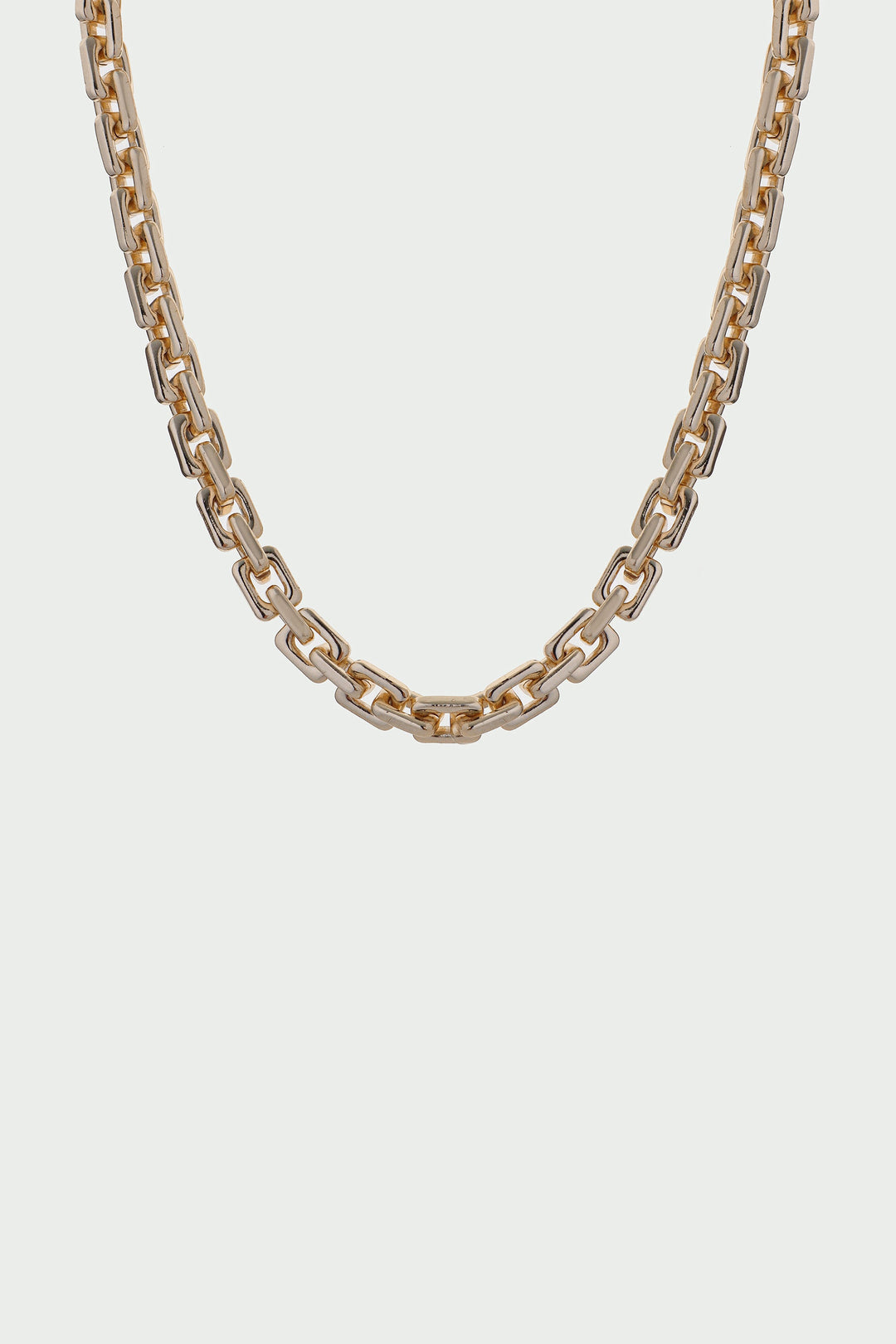 Gold chain necklace on a light gray background