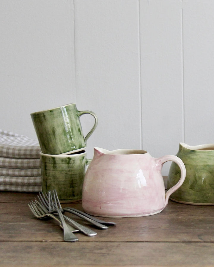 pink wonki ware ceramic jug and green wonki ware mugs