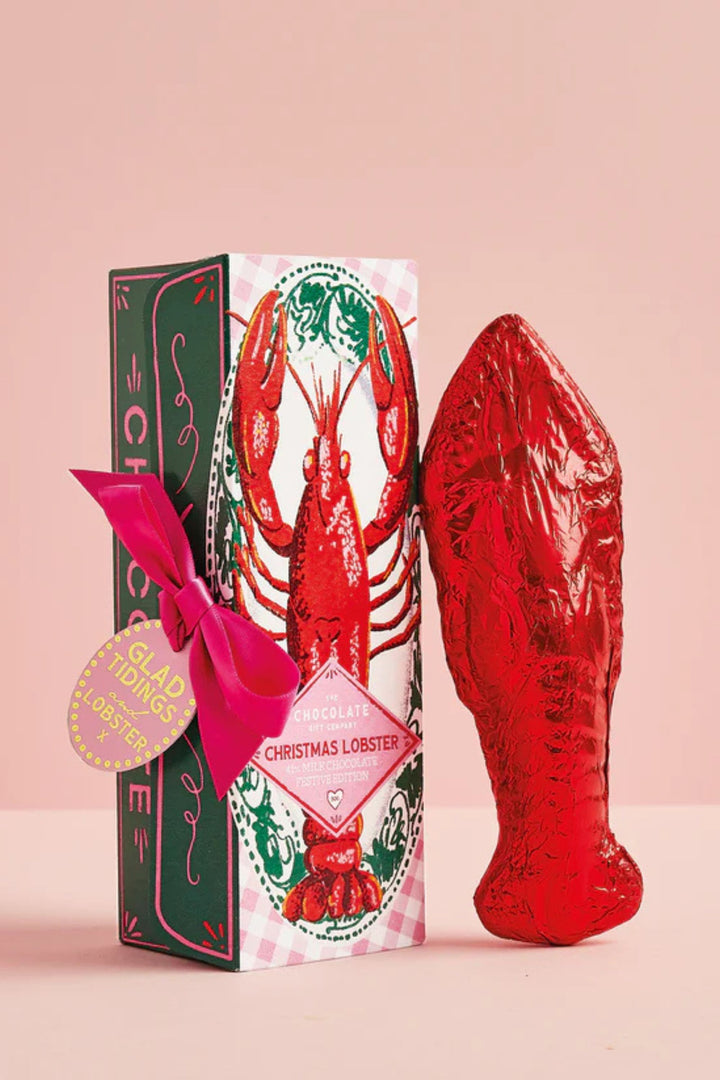 Red lobster-shaped product with a decorative box on a pink background