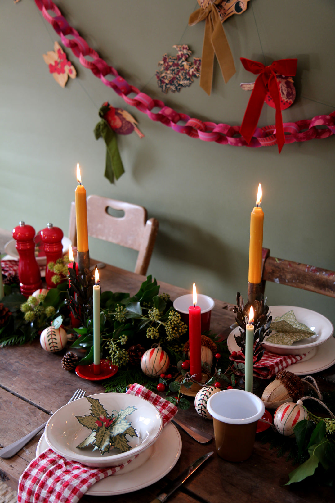 Decorative Christmas table setting with candles, plates, and festive decorations.